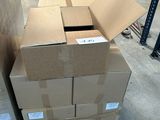 des cartons empilés sur des palettes dans un entrepôt, avec des palettes en arrière-plan
