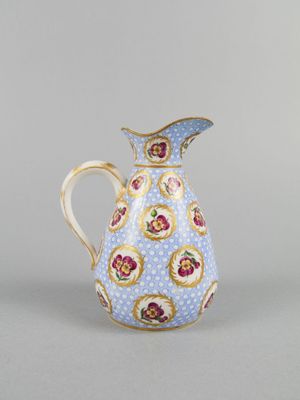 a blue and white pitcher with a floral design on it