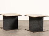une paire de tables en béton noir et blanc posées sur un sol en ciment