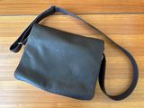 a black leather purse sitting on top of a wooden floor