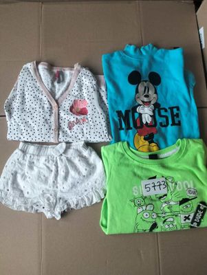 three children ' s clothing items are sitting on a cardboard box