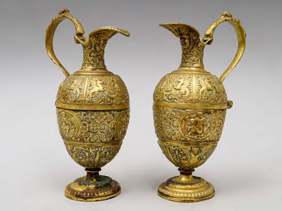 paire de vases anciens en laiton, munis d'anses et posés sur des socles