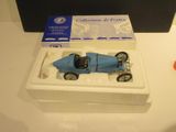 a blue toy car in a white box on a table