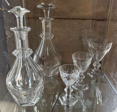 a glass table with a lot of wine glasses and a decanter