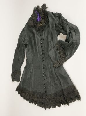 une image représentant un manteau vert orné de dentelle noire