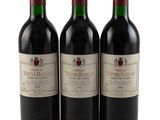 trois bouteilles de vin rouge posées l'une à côté de l'autre sur une surface blanche