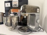 a silver mixer sitting on a counter next to other kitchen appliances
