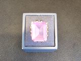une photo d'une bague rose posée dans une boîte sur une table