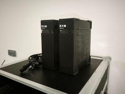 deux enceintes noires posées sur un boîtier noir