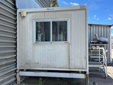 a small white building with a window on the side of it