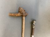 a wooden stick with a bird on it next to a metal pipe