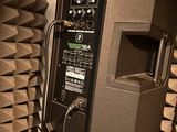 a speaker that is sitting on a stand in front of a wall