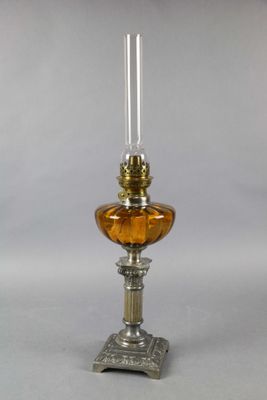 une lampe à huile à l'ancienne, surmontée d'un abat-jour en verre