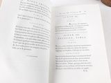 a book open on a table with a cup of coffee on it