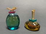 two bottles of perfume sitting next to each other on a table