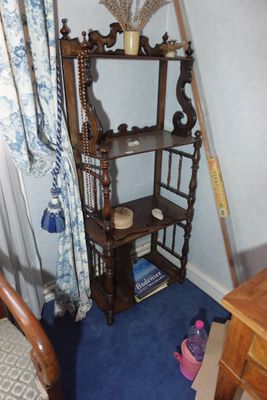 une étagère en bois sur laquelle est posé un miroir, à côté d'une chaise
