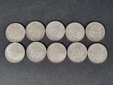 six pièces d'argent sont disposées en rangée sur une surface noire