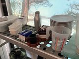 a metal shelf with various items on it in front of a window