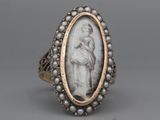 an antique silver ring with a picture of a woman holding a child