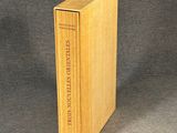 un vieux livre à la couverture en bois posé sur une table