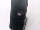 a broken cell phone sitting on a stand on a white surface