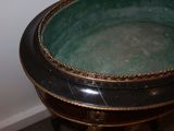 a black and gold table with a green bowl on it
