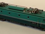a green toy train on a white surface with a white background