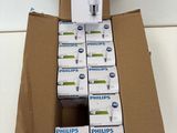 Des boîtes d'ampoules Philips sont empilées sur une boîte en carton