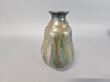 a blue and green vase sitting on a white table