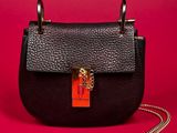 a black and red purse with a chain on a red background