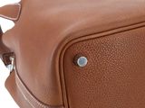 the back of a brown leather bag with a handle on it
