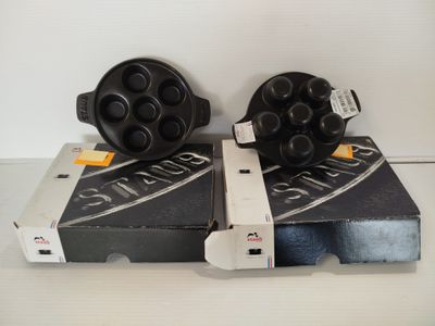 deux beignets noirs et blancs posés sur une boîte