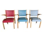 quatre chaises colorées sont alignées en rang sur un fond blanc