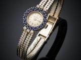 a close up of a wrist watch with blue sapphires on it