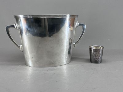 une coupe en argent et une autre coupe en argent posées sur une table