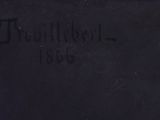 an old black book with writing on it sitting on a table