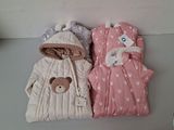 deux sacs de couchage pour bébé posés côte à côte sur une table