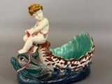 une figurine représentant une femme assise dans un bateau