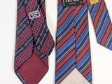 two ties with different colors and designs on them on a white surface
