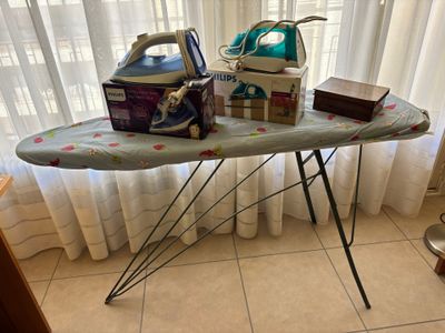 a ironing board with a iron and a box on it