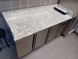 a kitchen counter with a sink and a refrigerator in it