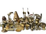a large collection of brass objects on a white surface