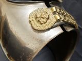 a silver vase that has a gold decoration on it