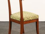 a wooden chair with a green upholstered seat