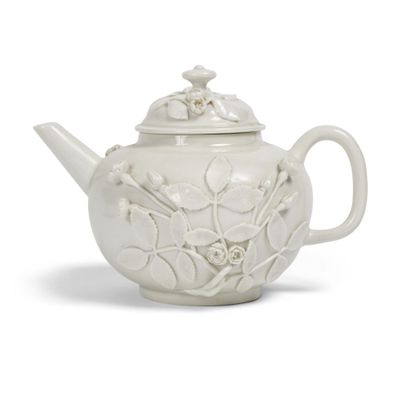 une théière blanche avec un couvercle et des fleurs dessinées dessus
