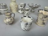 many different types of vases and cups on the table