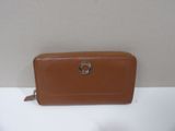 tan leather wallet with a metal ring on the front