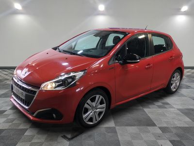 a red car is parked in a room with a checkered floor