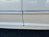 une voiture blanche dont la poignée de porte est cassée