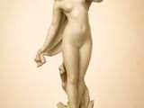 statue d'une femme nue tenant une fleur à la main